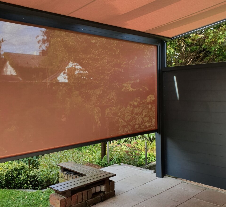 Terrasse mit seitlicher Sonnenschutzmarkise in Orange und einer modernen Überdachung. Der Sichtschutz bietet Privatsphäre und Schutz vor der Sonne.